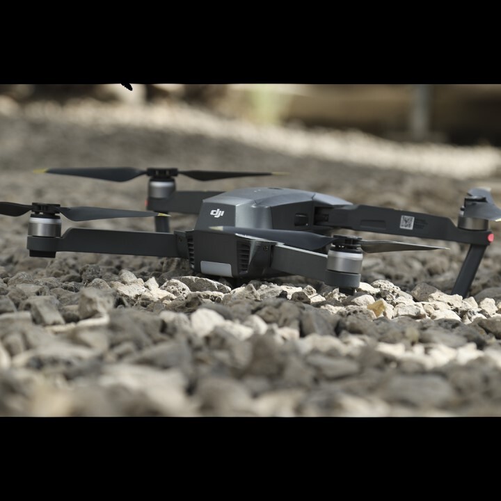 A drone resting on gravel.