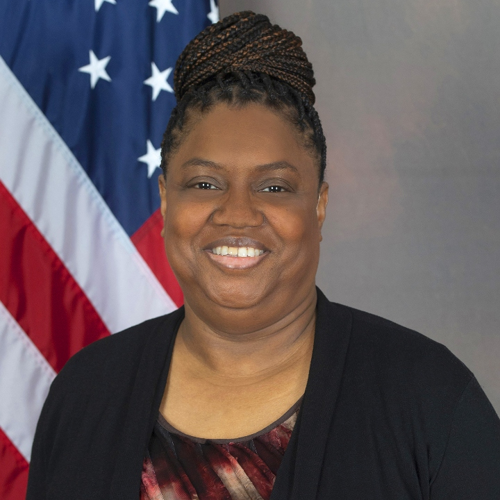 Mrs. Beatrice Wells in front of American flag.