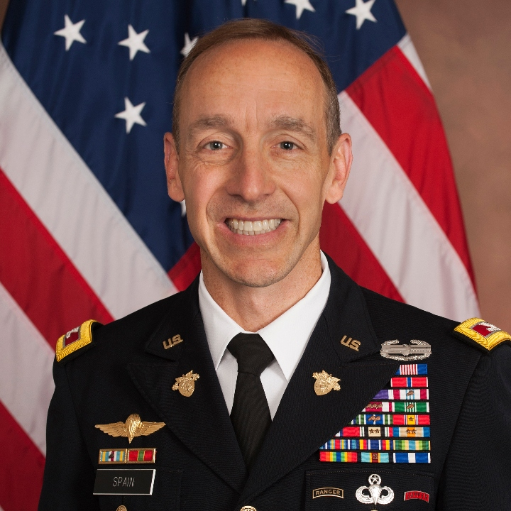 COL Everett Spain in ASU in front of American flag.