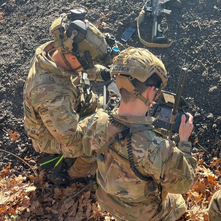 Two cadets looking at monitors while working outside