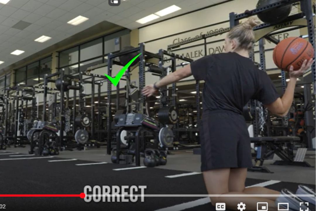 Woman prepares to throw a basketball.