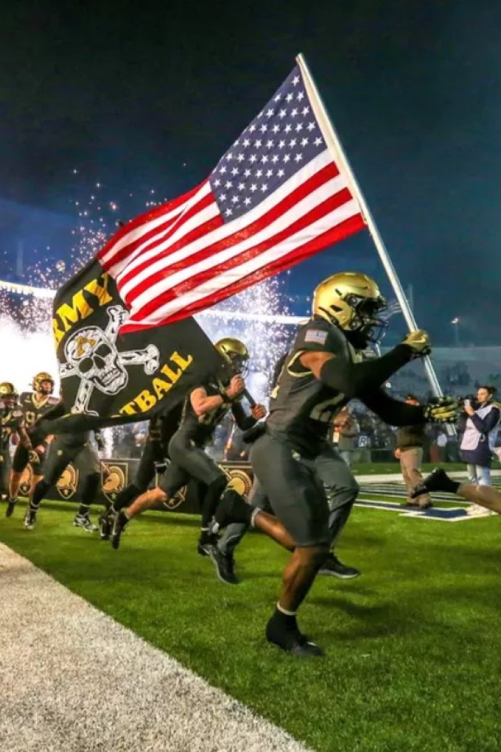 A Black Knight carries the American flag onto the football field. 