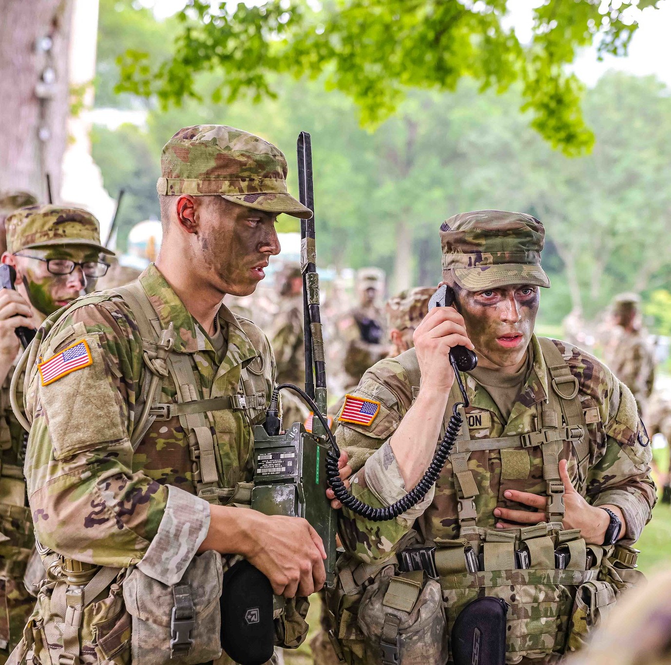 Two cadets talk on a military radio.