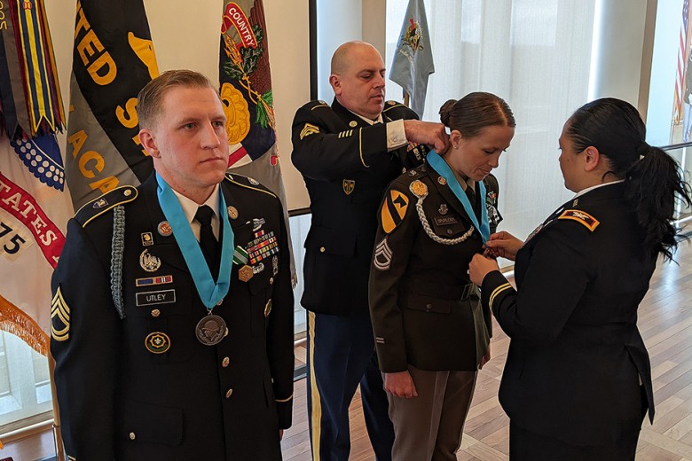 U.S. Army Garrison West Point Command Sgt. Maj. Rusty Lane places a Sergeant Audie Murphy Club ribbon and medallion on Sgt. 1st Class Megan Spurlock during a ceremony Friday at the Haig Room on West Point. The SAMC recognizes Army noncommissioned officers who exemplify leadership characterized by personal concern for the needs, training, development, and welfare of Soldiers and concern for families of Soldiers.