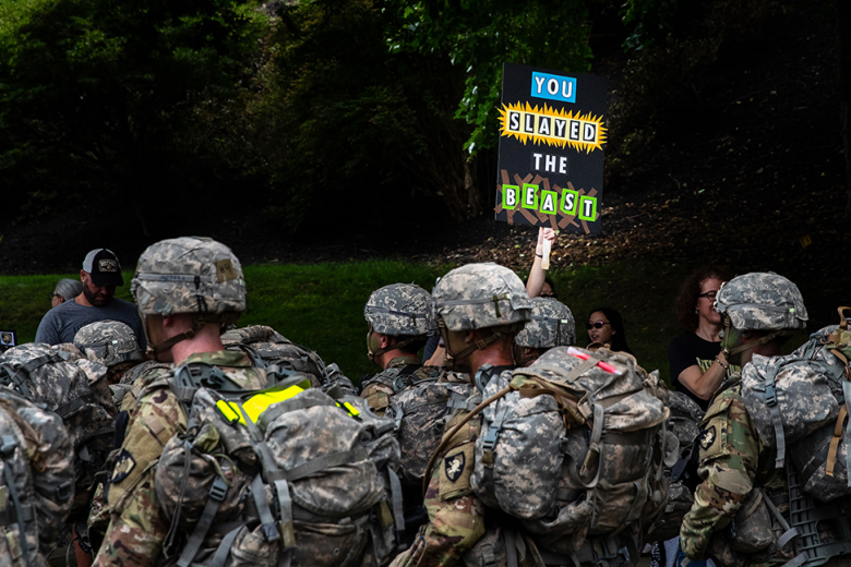 A family member of a Class of 2025 cadet holds a sign congratulating the new cadets on ʻSlaying the Beastʼ as they complete their initial summer training at West Point.  	