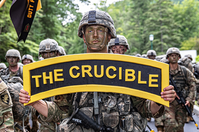 A new cadet from the U.S. Military Academy Class of 2025 carries a sign, ʻThe Crucible,ʼ as his classmates complete the final mile of March Back Monday at West Point.  