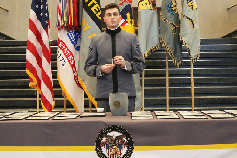 Class of 2024 Cadet and Class President Thomas Ward holds a container of gold shavings from previous melts before pouring it into the crucible Friday at Crest Hall. 			 		              Photo by Eric S. Bartelt/PV