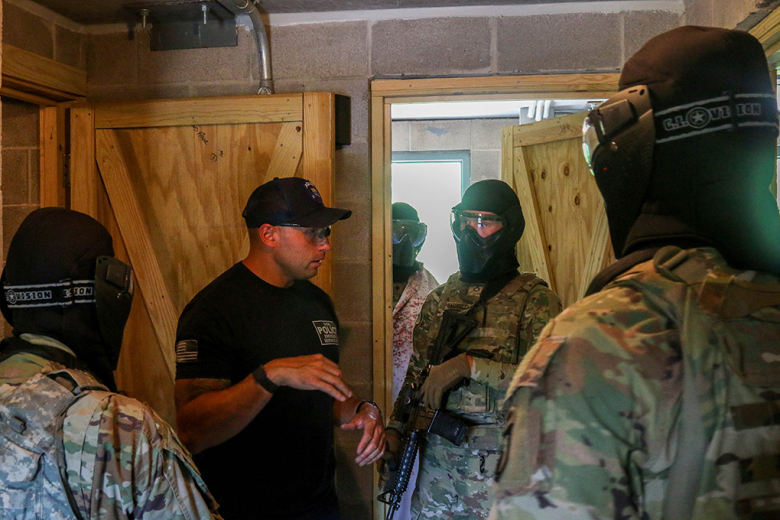 New York Police Departmentʼs Emergency Service Unit discusses improvements that should be made with Crusher Company, 1st Battalion, 187th Infantry Regiment, 3rd Brigade Combat Team, 101st Airborne Division (Air Assault) on July 15. The review is vital so Soldiers understand how to tactically move safely and successfully allowing minimum to no casualties.    (Photo by Spc. Kelvin Johnson Jr./40th Public Affairs Detachment)