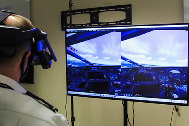 Lt. Col. James Schreiner, an associate professor in the Department of Systems Engineering, demonstrates the latest technological advancements in virtual aviation training while he looks at the screen Tuesday at West Point.  