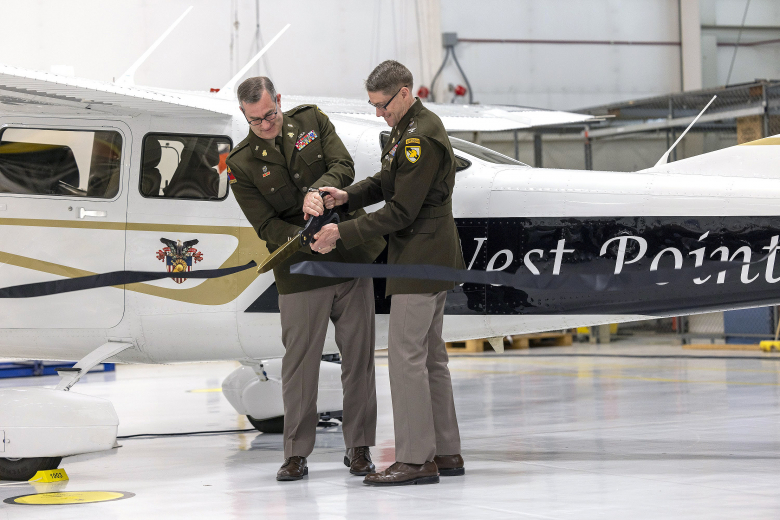Brig. Gen. Shane Reeves, the 15th Dean of the Academic Board, and Col. Bret VanPoppel, Department of Civil and Mechanical Engineering deputy head, cut the ribbon during the Aircraft Dedication Ceremony March 23 at the 2nd Aviation Detachment's Hangar.     (Photo by Christopher Hennen/USMA PAO)