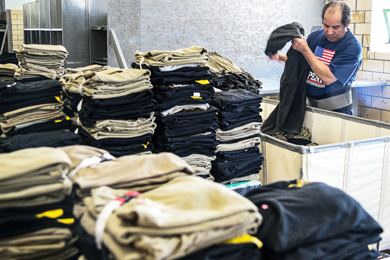Jorge Delacruz, a West Point Logistics Readiness Center Cadet Laundry Facility employee for more than 20 years, neatly folds and organizes clean uniforms at the unique facility. After the clothes are folded, they are rechecked for quality before being wrapped in plastic for the customer.
