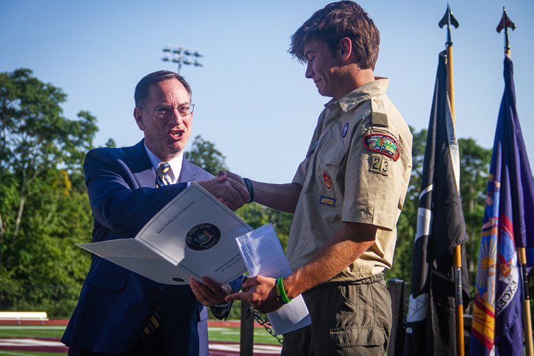 James I. O'Neill High School faculty and community members gathered at Waldo Wood Memorial Field to witness West Point Troop 23 Eagle Scout candidate Chad Haley Jr.ʼs (above) presentation as he unveiled the completion of the Prisoner of War/Missing in Action Honor chair dedicated to veterans in the West Point community and across the Nation on Friday. Through a collaboration with the Hussey Seating Chair Company and other community members, Haley Jr. facilitated the ambitious project, as part of his Eagle