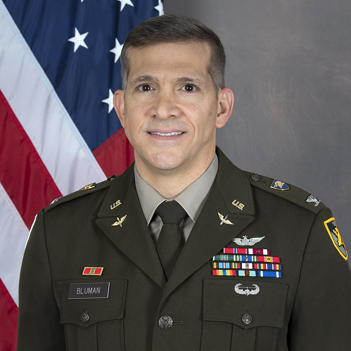 COL James Bluman in front of the US Flag