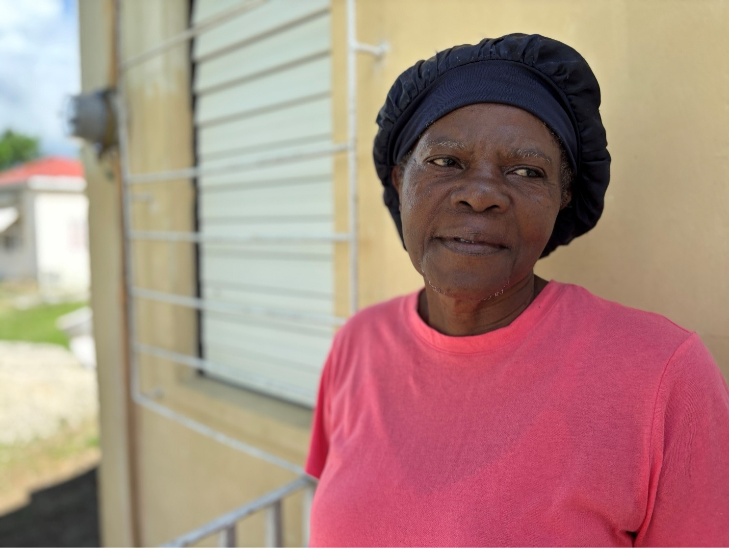 Cordeline beside her storm-damaged farm shop