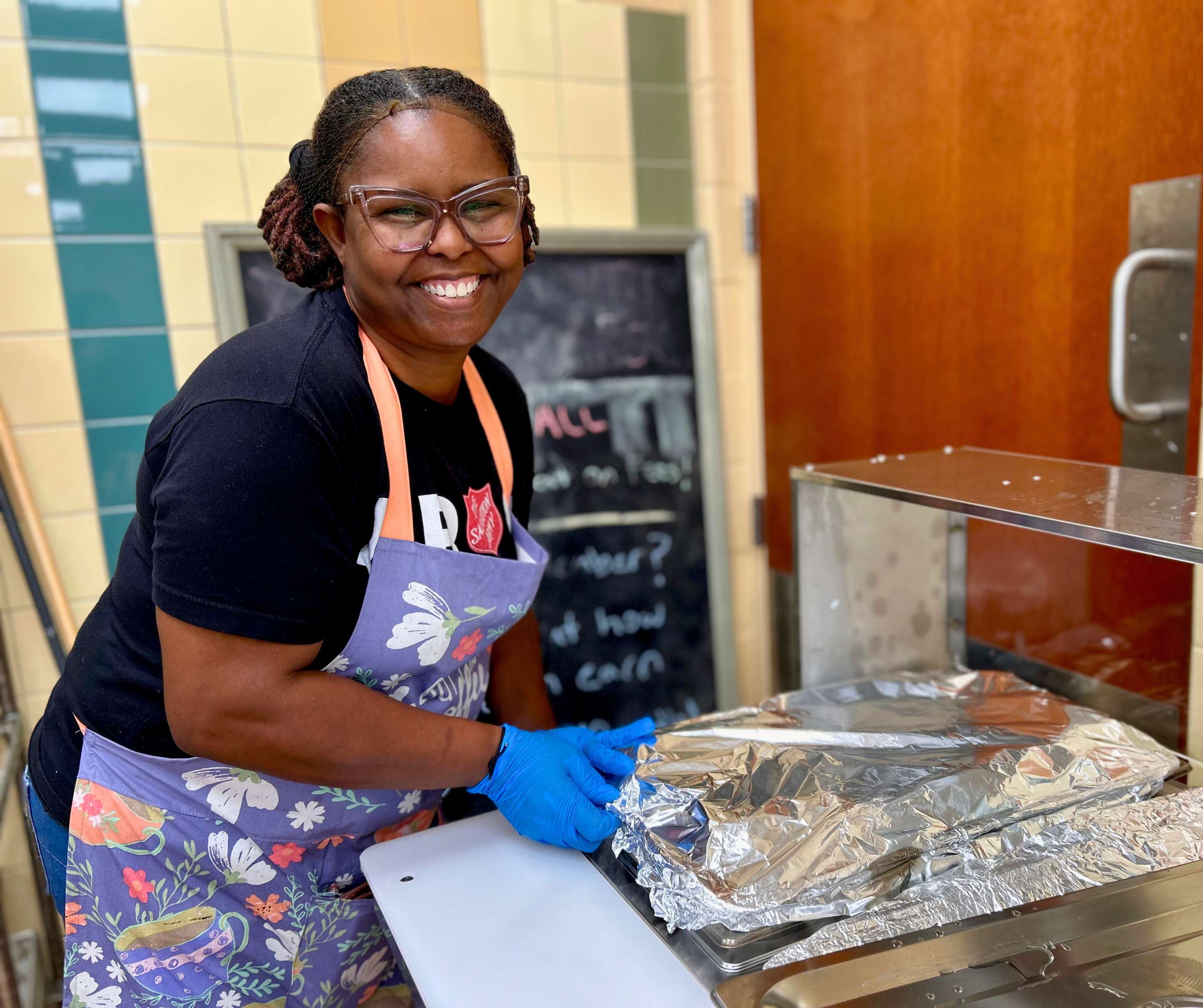 A volunteer prepares food in a Salvation Army kitchen.