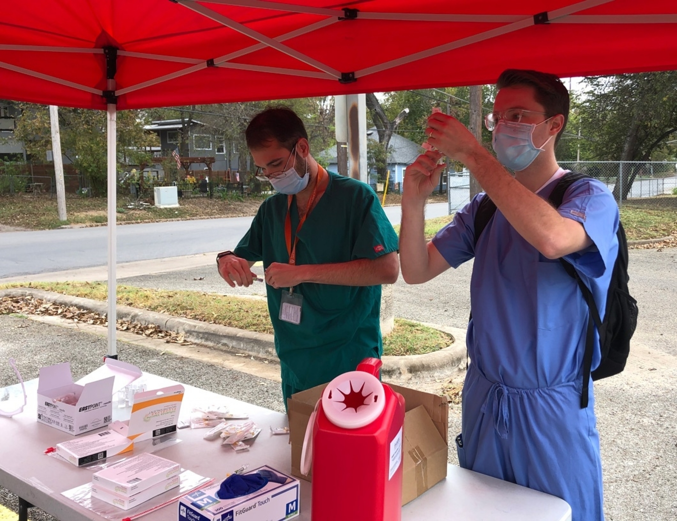 Two Dell Med students preparing flu shots.