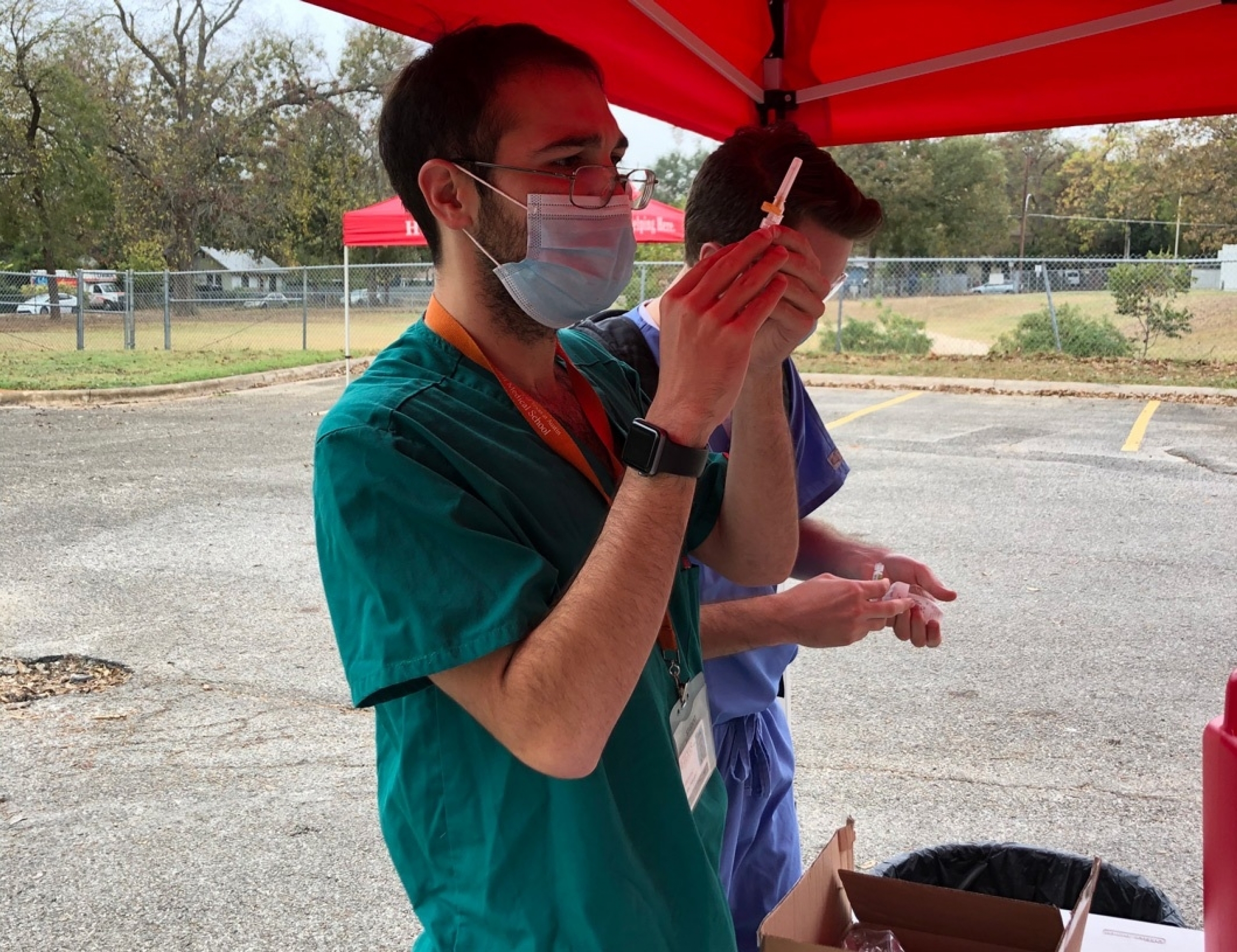 A Dell Med student preparing a flu shot.