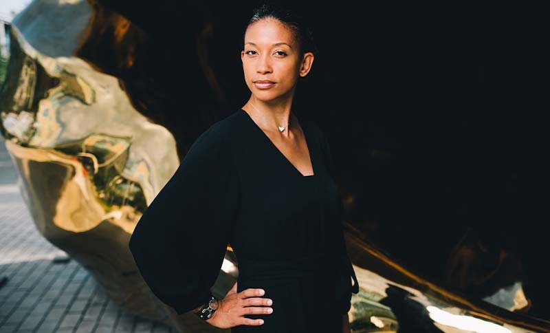 Donna Shanor stands for a portrait in front of an art structure outside the Dell Medical School campus.