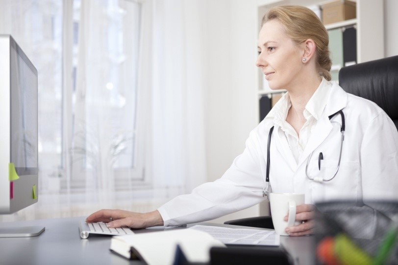 A female doctor works at her desktop office computer