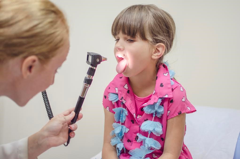 An FNP examines a child’s throat.