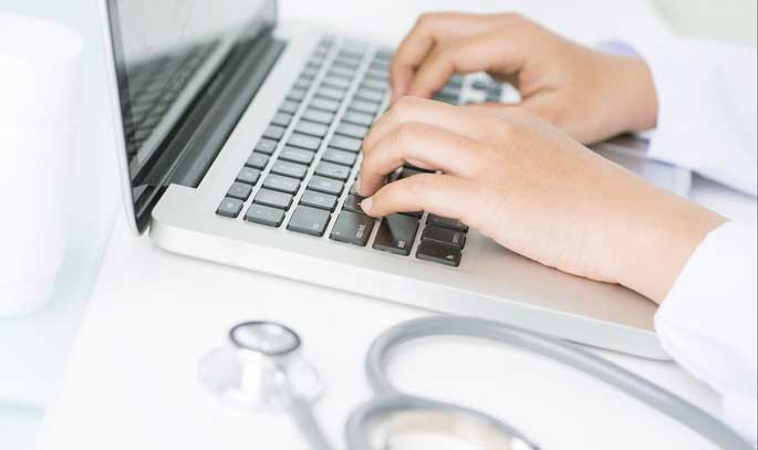 A nurse uses a laptop