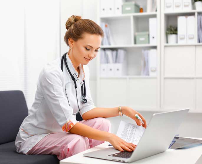 Nurse looks at laptop
