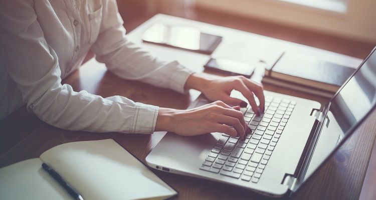 Lady typing on laptop keyboard