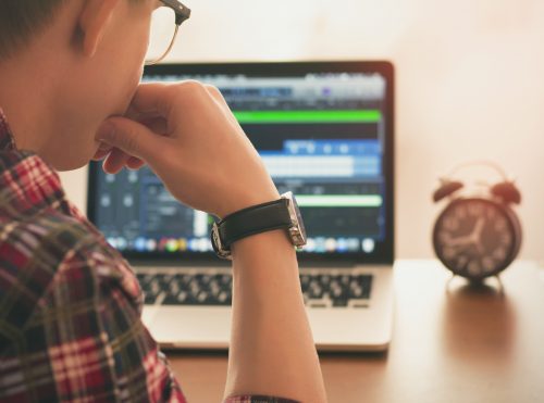 A young man works on a laptop.
