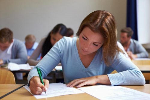 Female student sitting at a desk working on a worksheet.