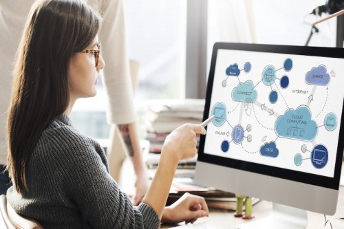 Woman points to cloud computing icons on a monitor