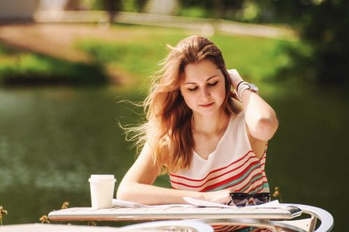 Finance student doing her homework outside
