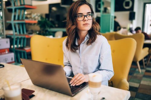 A cybersecurity professional works on a laptop.