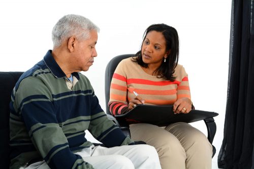 African American female psychologist having a consultation with an elderly man with grey hair