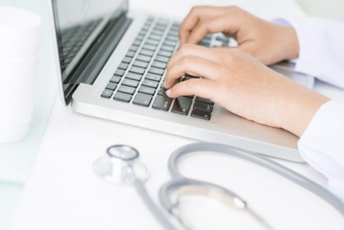 Family nurse practitioner typing on laptop