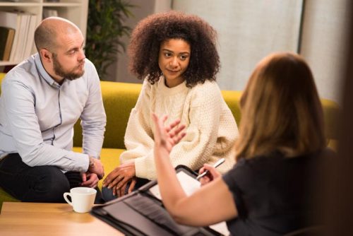 Young Mixed Race Couple Sitting and Listening to Their Counselor