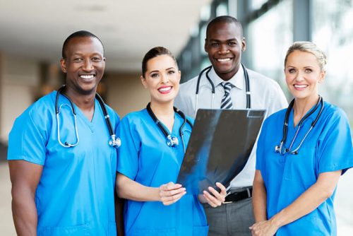 Two female and a male nurse examining an x-ray photo with a male doctor