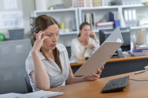 Woman staring blankly at her desk.