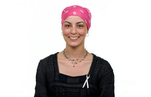 Smiling female cancer patient with a pink scarf covering her head