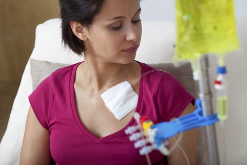Young female patient in red shirt receiving chemotherapy