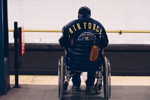 Depressed Air force veteran in wheelchair waiting in the subway