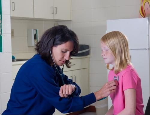 A female nurse practitioner giving a child an exam.