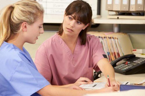 Two female nurses having a discussion.