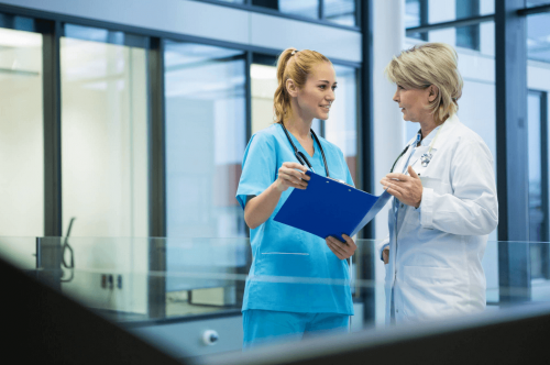 An FNP speaks with a nurse.