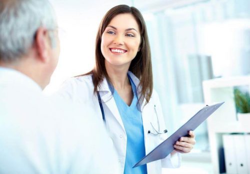 DNP nurse smiling with clipboard in hand.