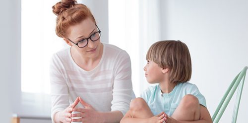 Young female counseling sad young boy