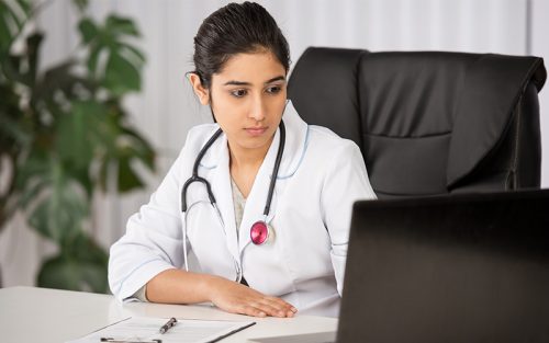 Young female doctor at laptop