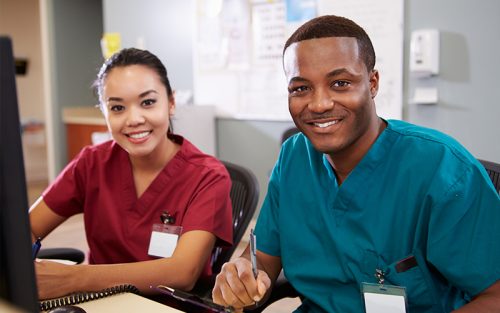 Two nurses smiling at viewer