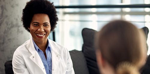 Happy black female counselor communicating with patient