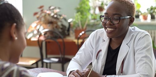 Smiling African American PMHNP working with a patient