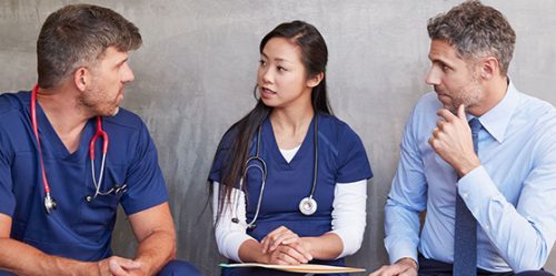 Businessman talks to young doctors